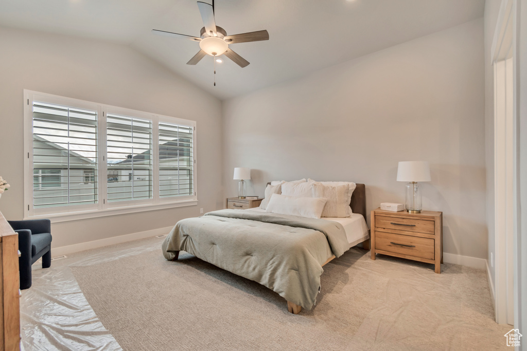 Carpeted bedroom with lofted ceiling, a ceiling fan, and baseboards