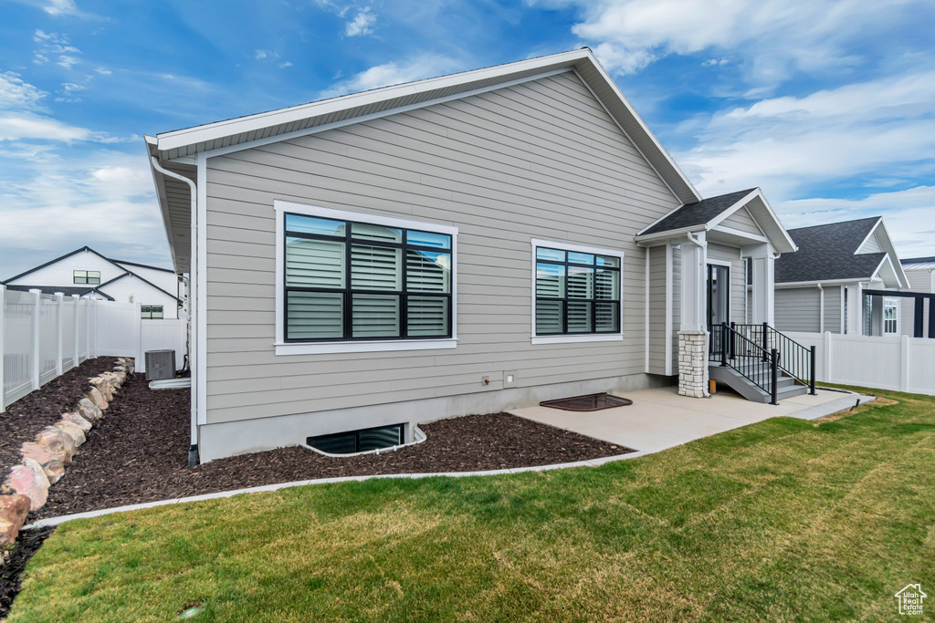 Back of house featuring a patio, a fenced backyard, and a yard