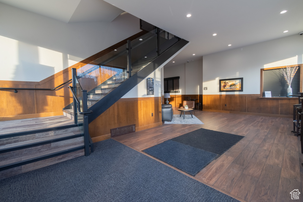 Staircase featuring hardwood / wood-style flooring and wooden walls