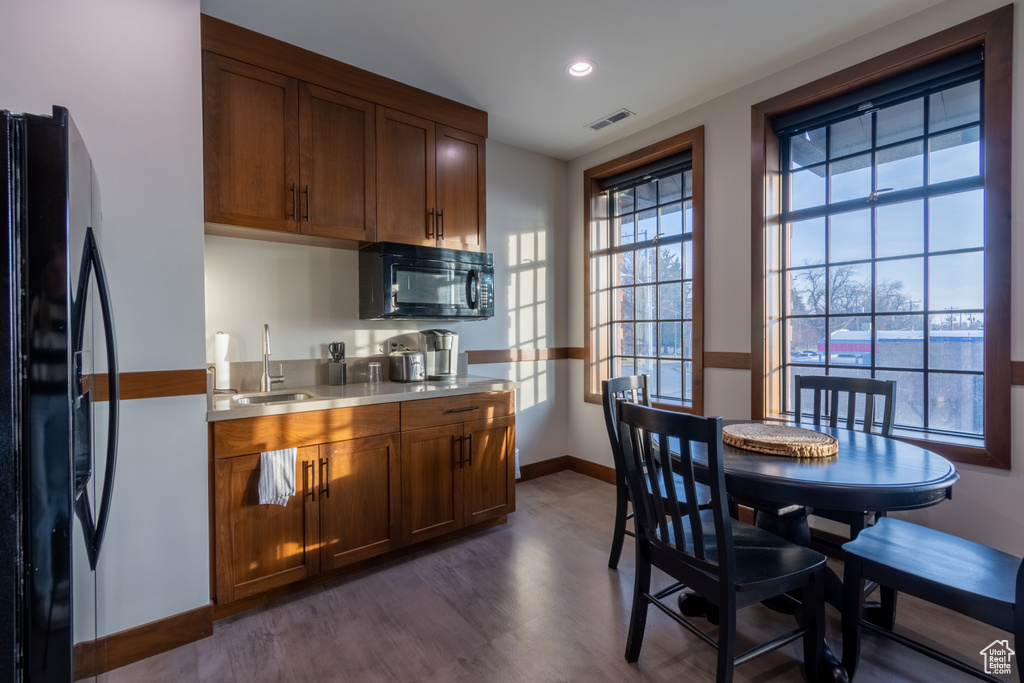 Kitchen with sink, dark hardwood / wood-style floors, and black appliances
