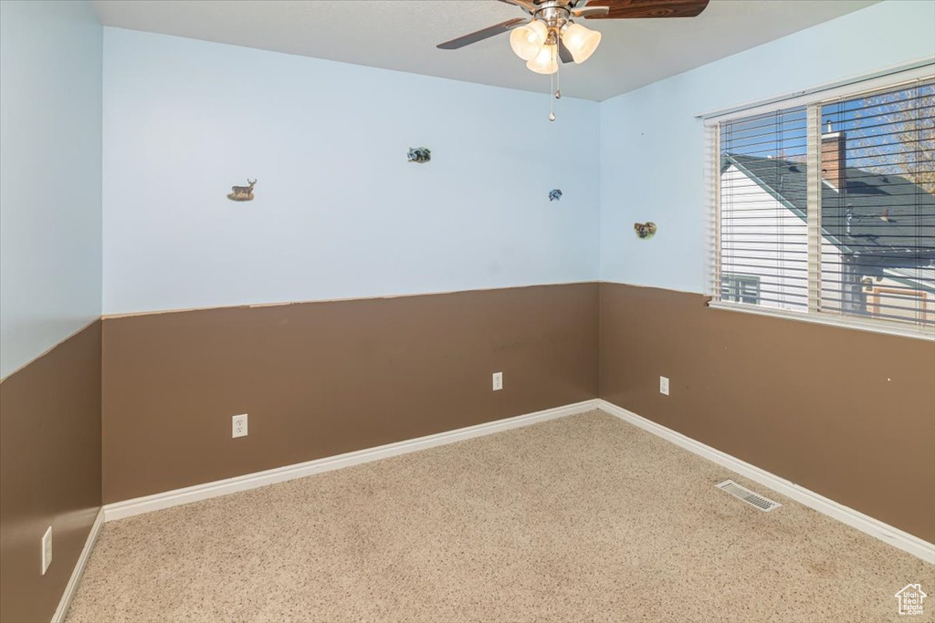 Empty room featuring ceiling fan and carpet