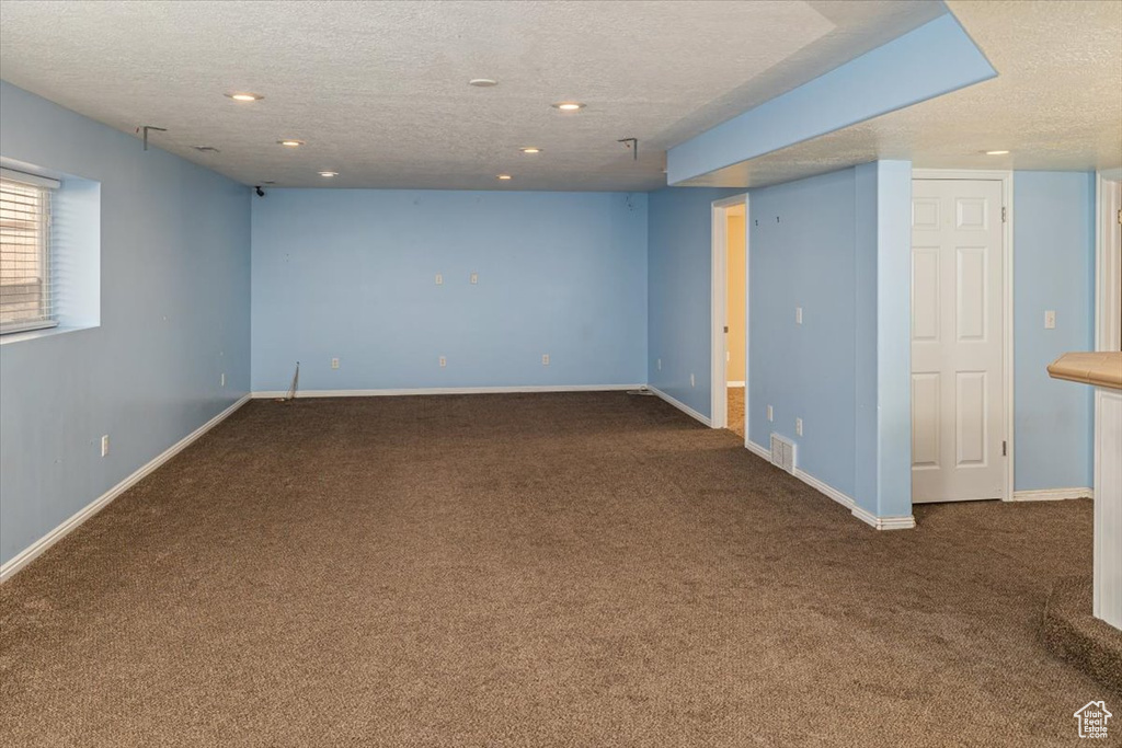 Unfurnished room with carpet and a textured ceiling