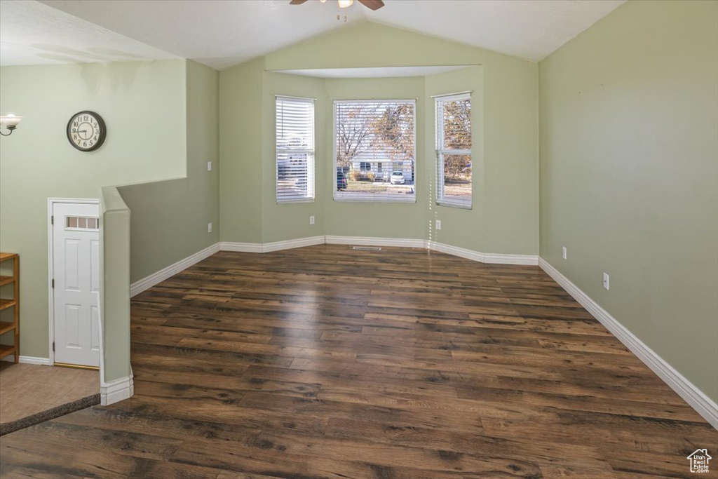 Unfurnished room featuring ceiling fan, dark hardwood / wood-style flooring, and lofted ceiling