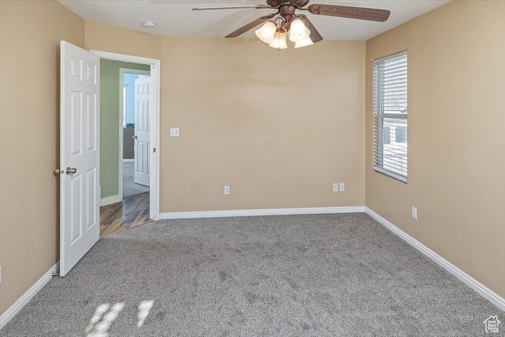 Carpeted spare room with ceiling fan