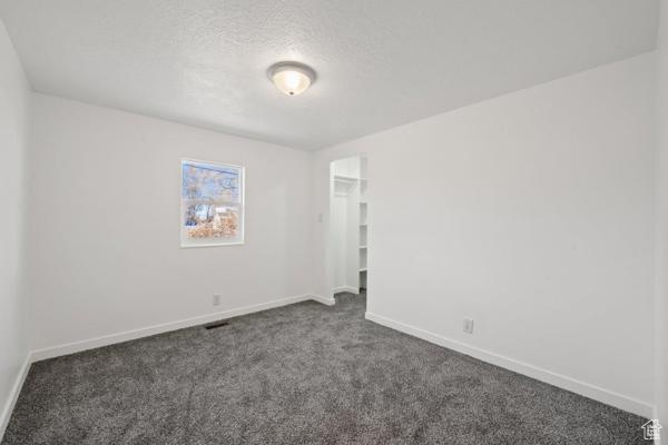 Carpeted spare room featuring a textured ceiling