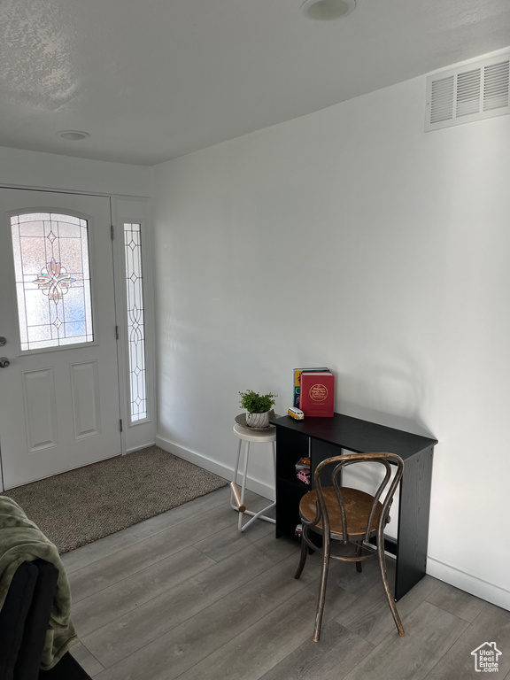 Entrance foyer featuring baseboards, visible vents, and wood finished floors