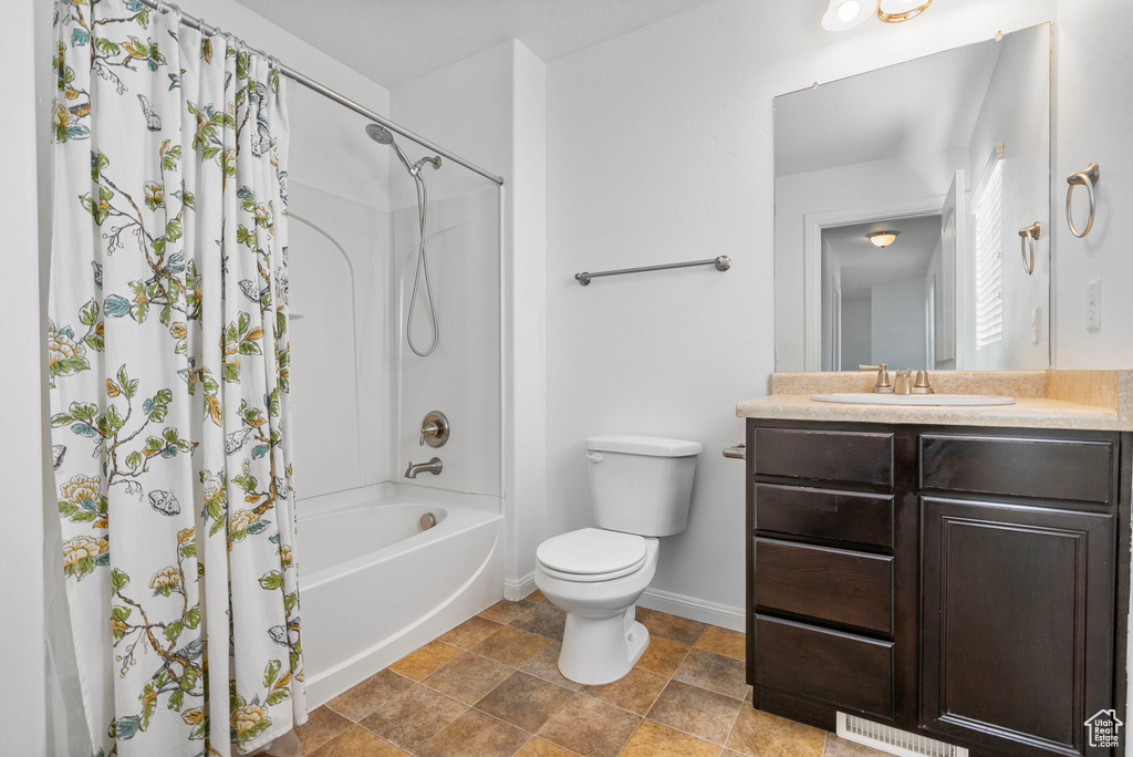 Full bathroom featuring vanity, shower / bath combination with curtain, and toilet