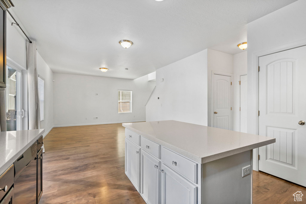 Kitchen featuring a textured ceiling, a kitchen island, and dark hardwood / wood-style floors