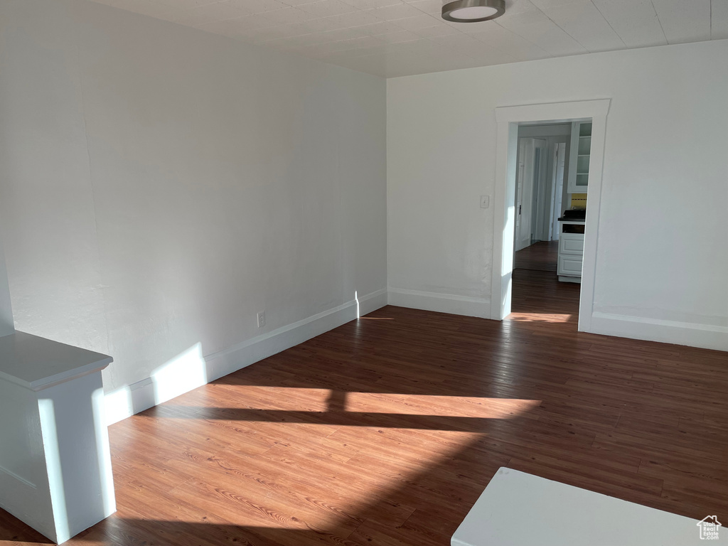 Empty room with dark hardwood / wood-style flooring