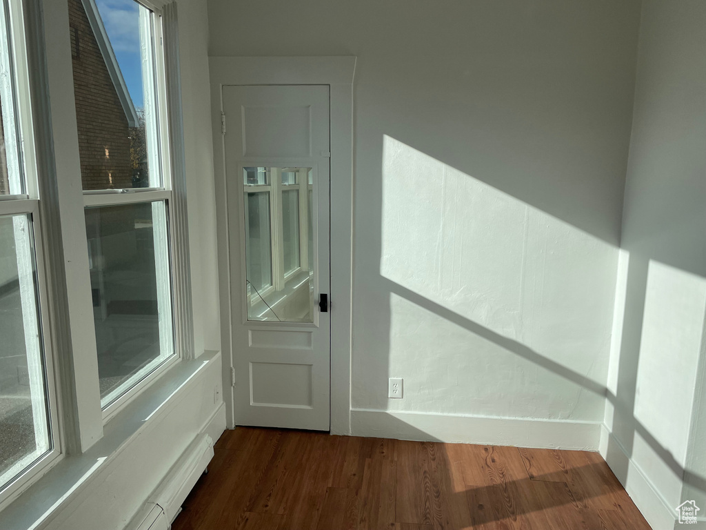 Doorway to outside with a healthy amount of sunlight and dark hardwood / wood-style floors