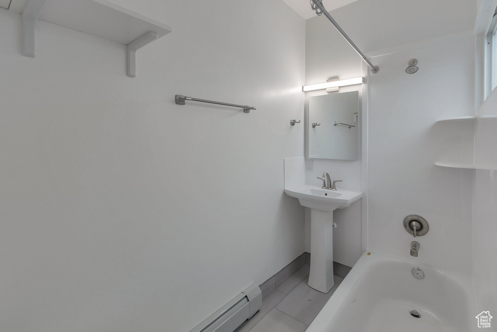 Bathroom with shower / bath combination and a baseboard heating unit