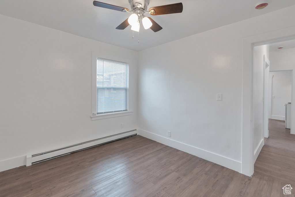 Spare room with ceiling fan, light hardwood / wood-style flooring, and a baseboard heating unit