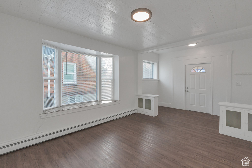 Foyer entrance featuring a baseboard heating unit and dark hardwood / wood-style flooring