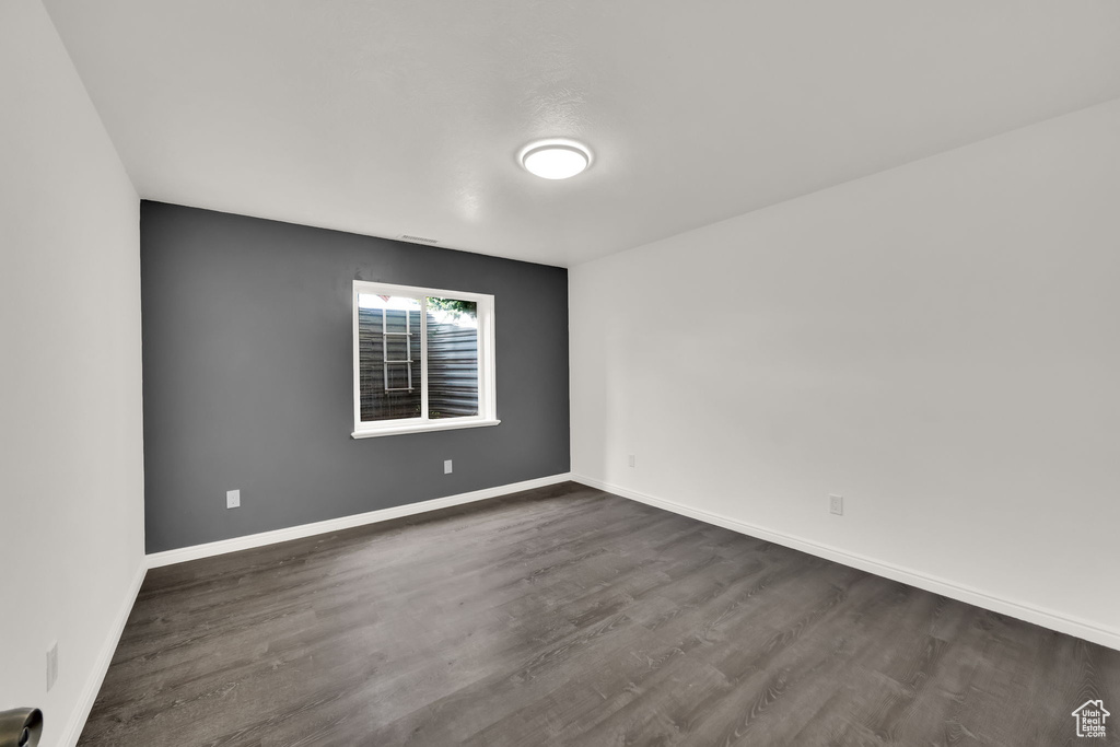 Spare room featuring dark wood-type flooring