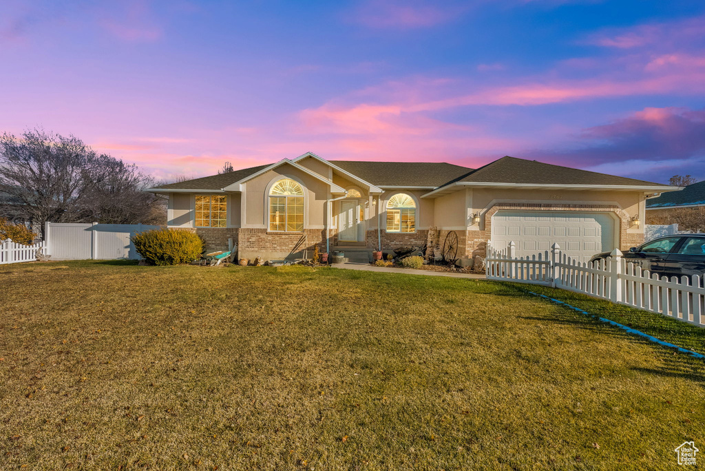 Ranch-style home with a yard and a garage