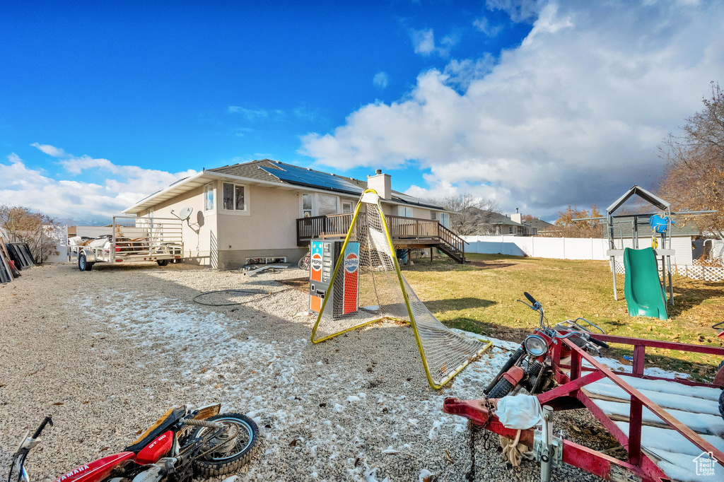 View of jungle gym featuring a yard and a deck