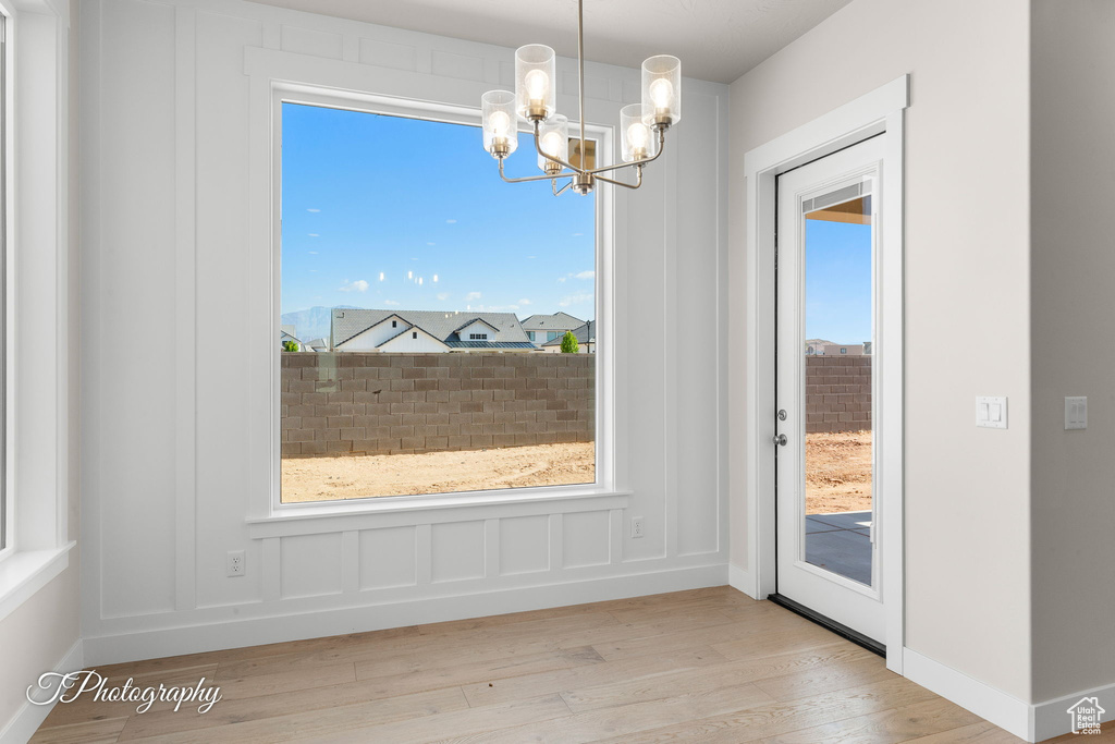 Unfurnished dining area featuring a chandelier and wood finished floors