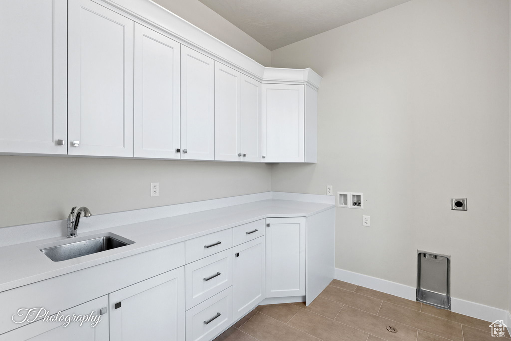 Laundry room featuring cabinet space, hookup for an electric dryer, washer hookup, baseboards, and light tile patterned flooring