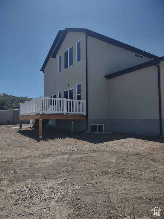 Rear view of property with a deck and stucco siding