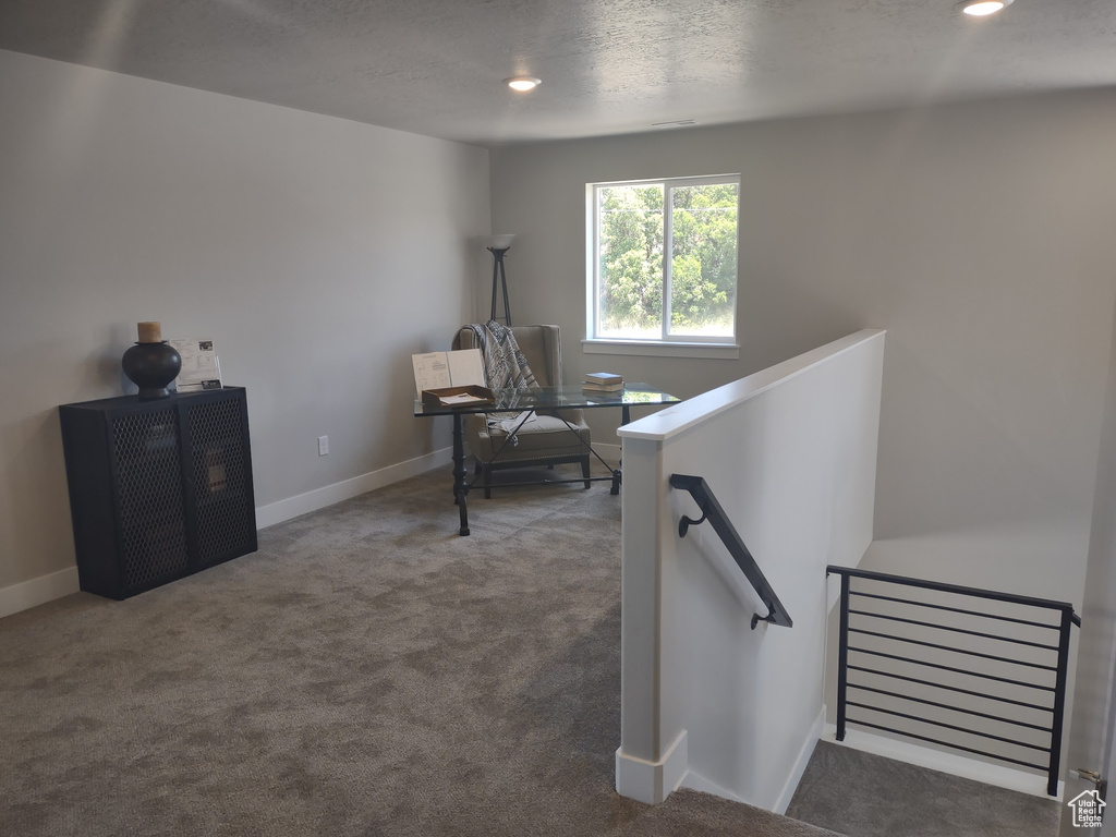 Living area with an upstairs landing, carpet flooring, a desk, recessed lighting, and a textured ceiling