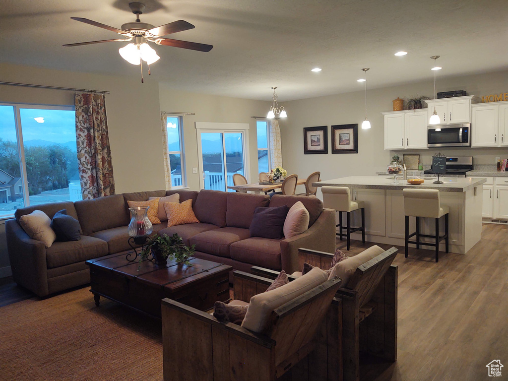 Living room featuring hardwood / wood-style flooring and ceiling fan with notable chandelier