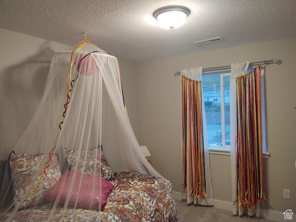 Carpeted bedroom featuring a textured ceiling