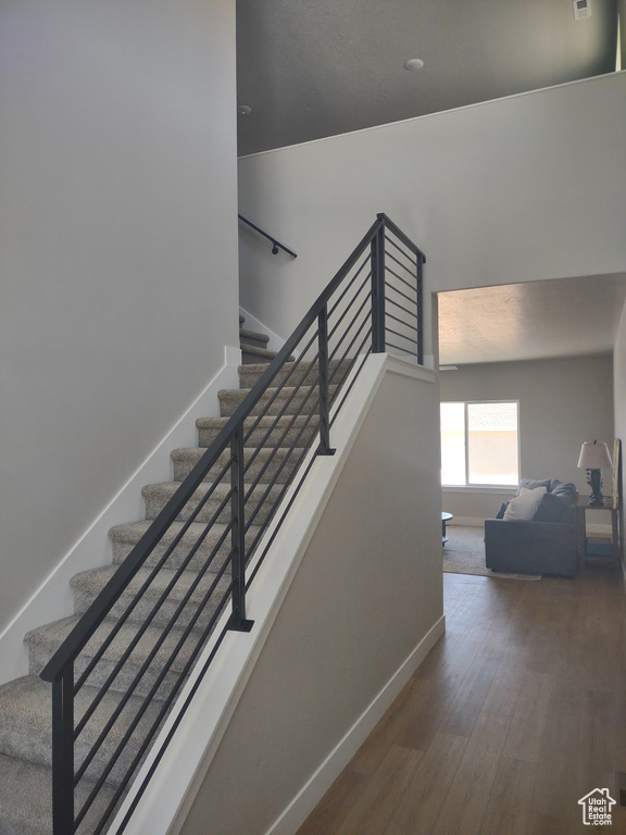 Stairway with wood finished floors and baseboards