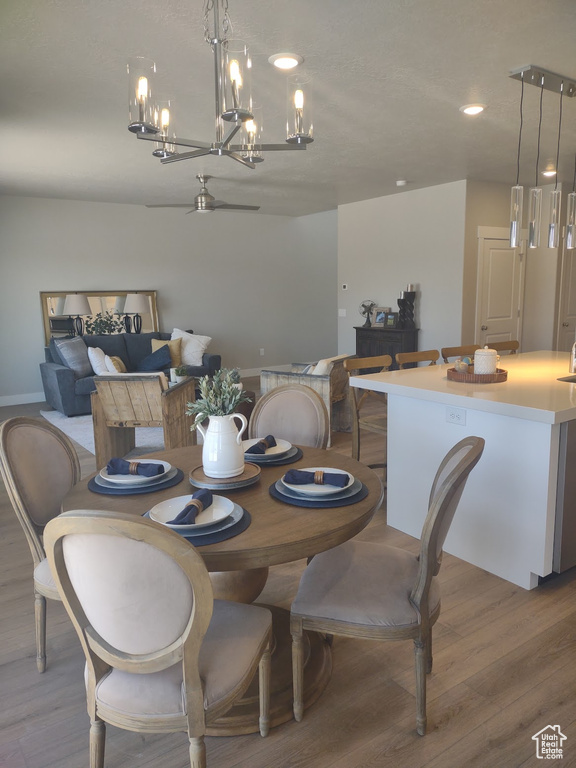 Dining space with a chandelier, light wood-style floors, and recessed lighting