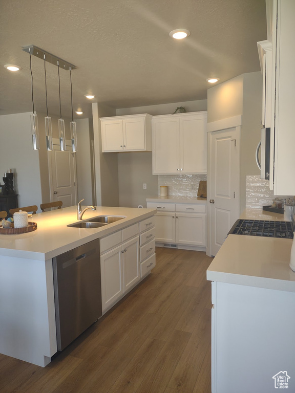 Kitchen featuring appliances with stainless steel finishes, dark wood-style floors, white cabinetry, tasteful backsplash, and recessed lighting