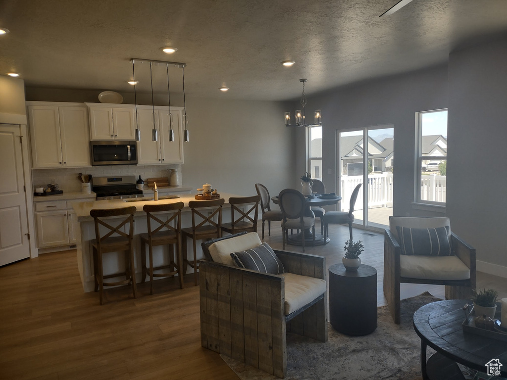 Living room featuring dark wood-style floors, a chandelier, and recessed lighting