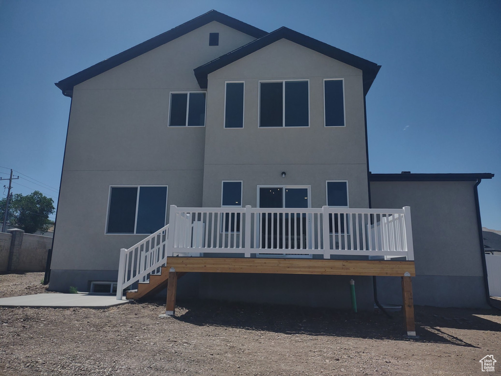 Rear view of house with a deck and stucco siding