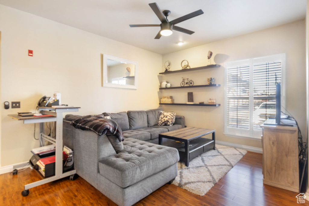 Living room with ceiling fan and dark hardwood / wood-style flooring