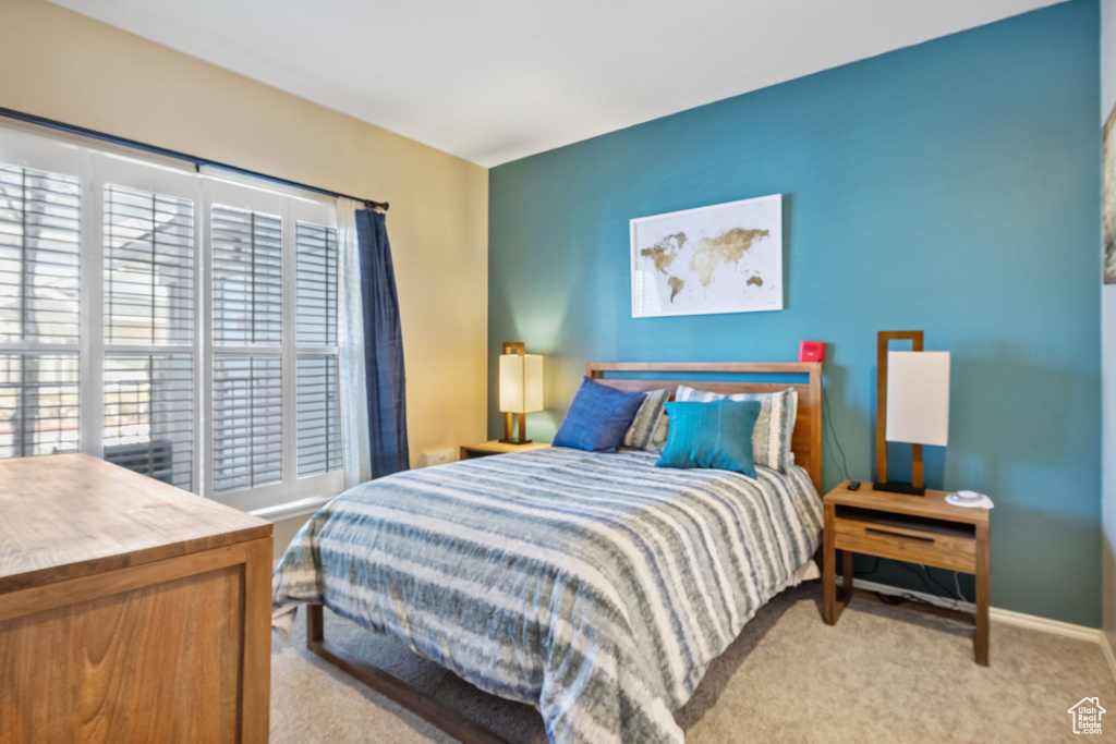 Bedroom with multiple windows and light colored carpet