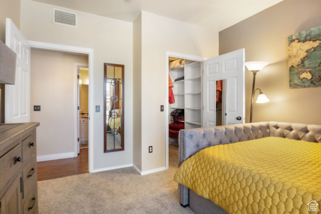 Bedroom featuring light carpet, a walk in closet, and a closet