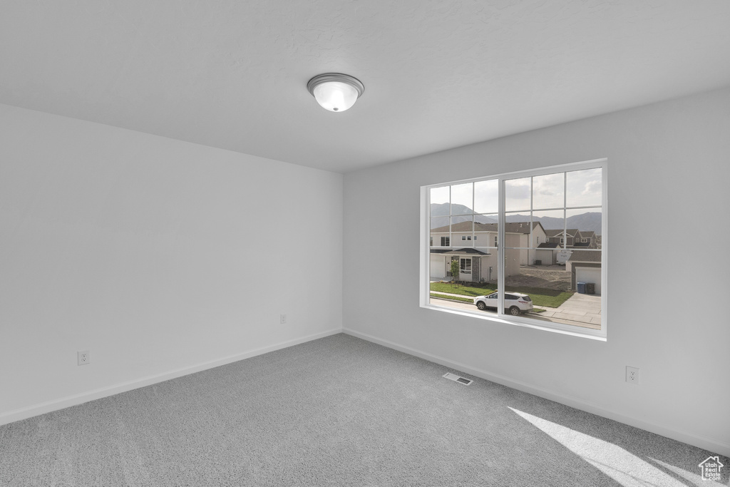 Spare room with carpet and baseboards