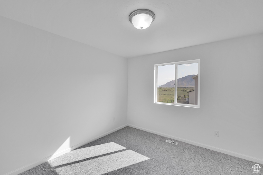 Carpeted spare room with baseboards