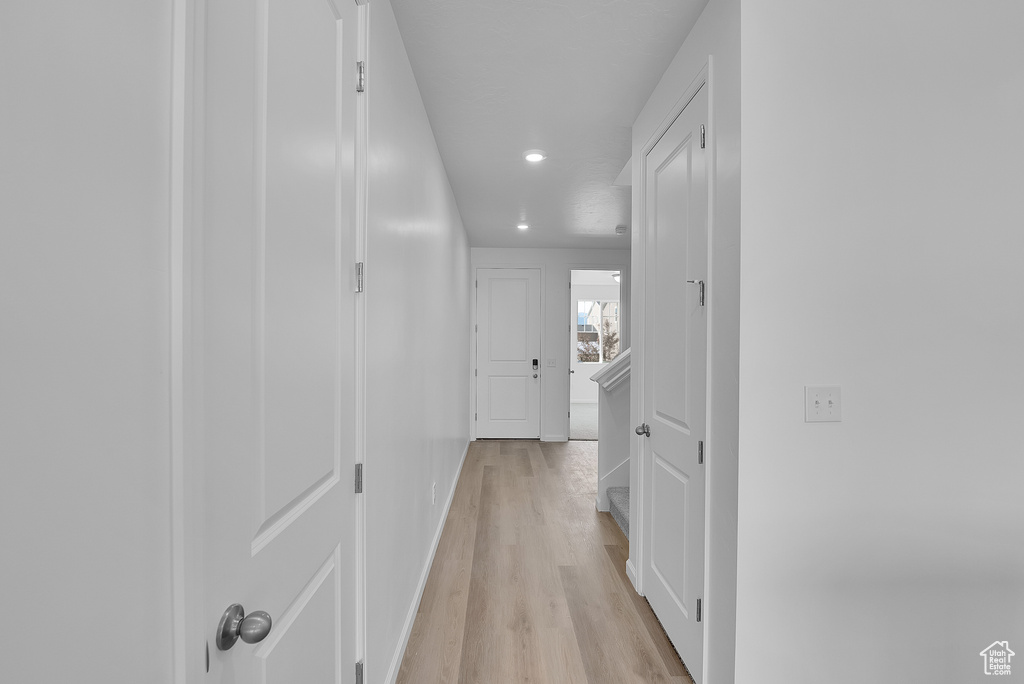 Hall with light wood-type flooring, recessed lighting, and baseboards