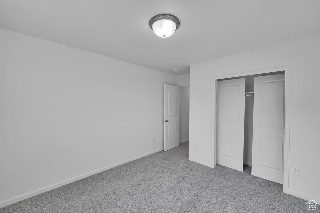 Unfurnished bedroom with carpet floors, baseboards, and a closet