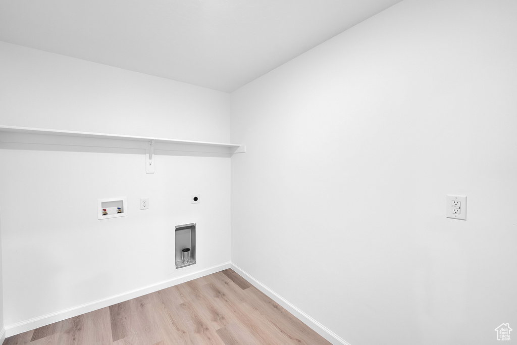 Laundry room with hookup for a washing machine, light wood-style flooring, hookup for an electric dryer, and baseboards