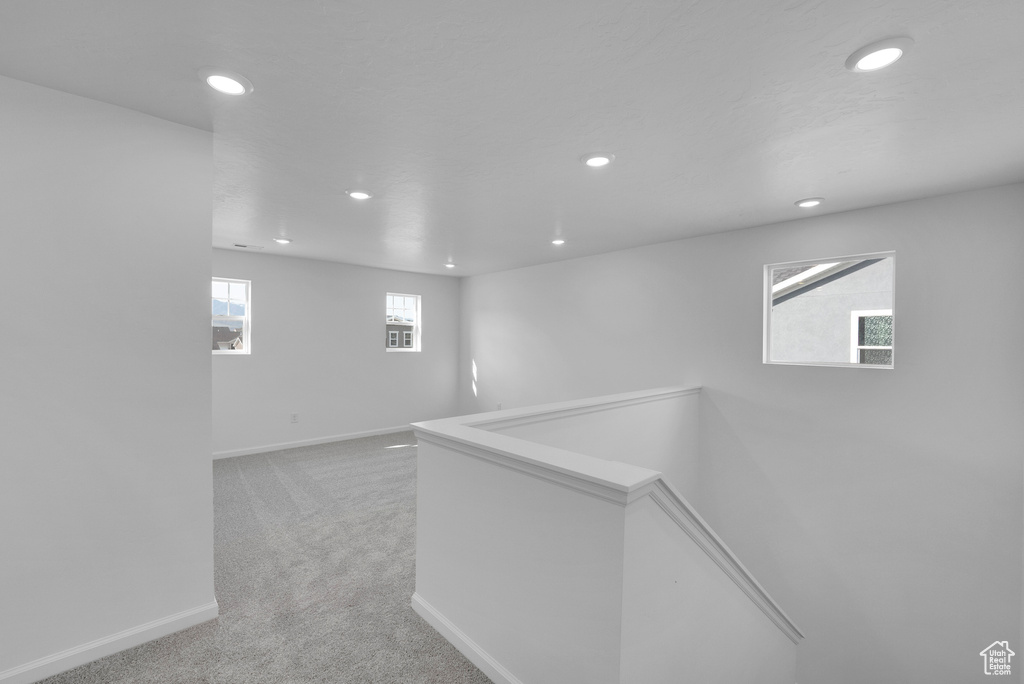 Hallway featuring recessed lighting, light colored carpet, baseboards, and an upstairs landing