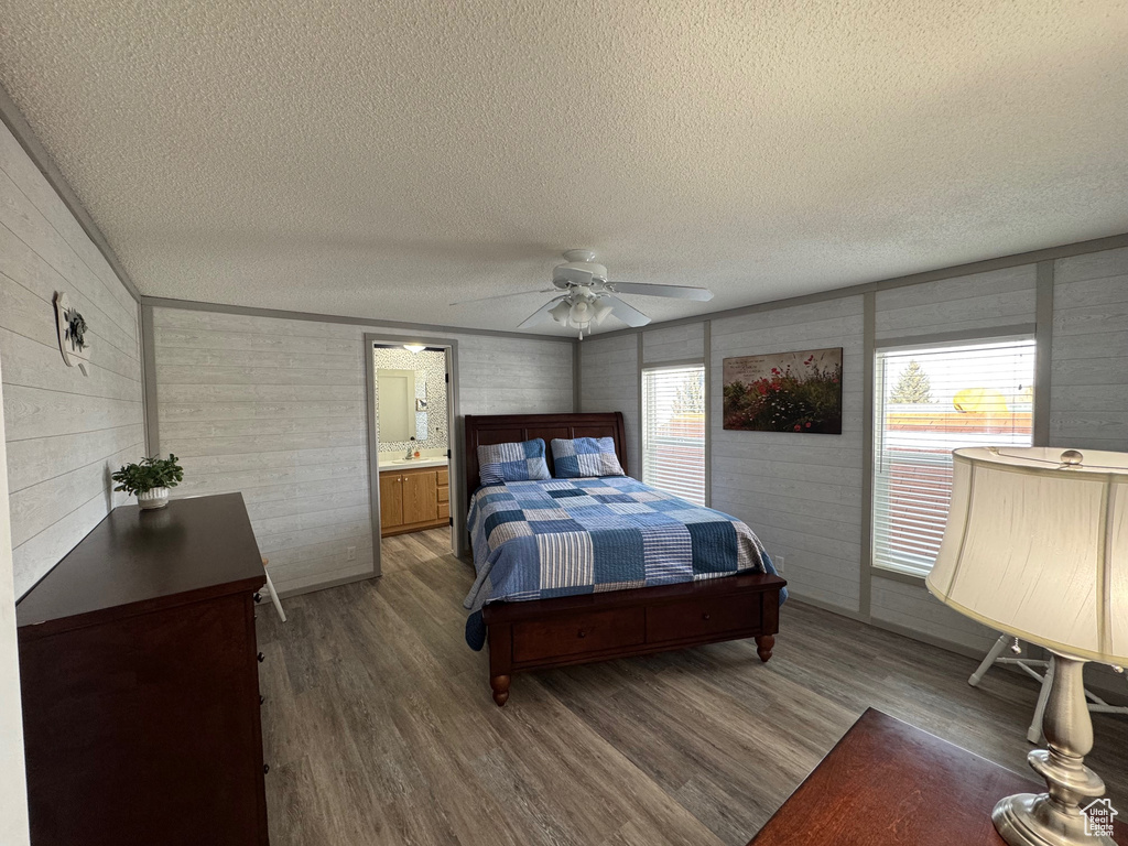 Bedroom featuring hardwood / wood-style floors, ceiling fan, a textured ceiling, and multiple windows