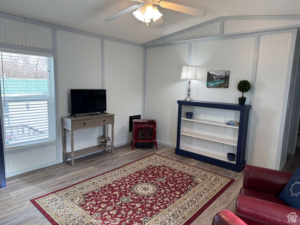 Sitting room with ceiling fan, wood-type flooring, and vaulted ceiling