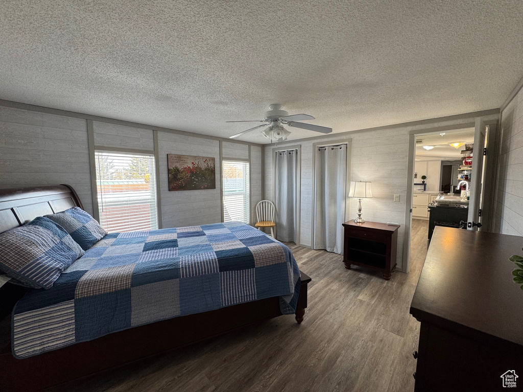 Bedroom with wood-type flooring, a textured ceiling, and ceiling fan