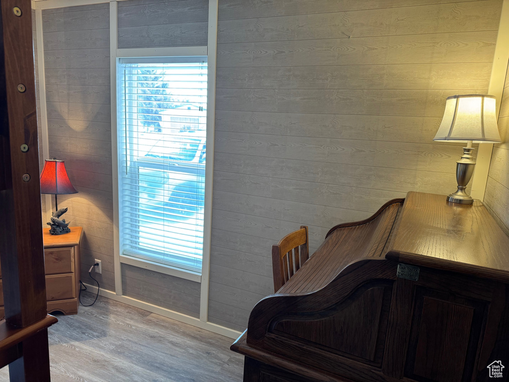 Bedroom featuring light wood-type flooring and wooden walls