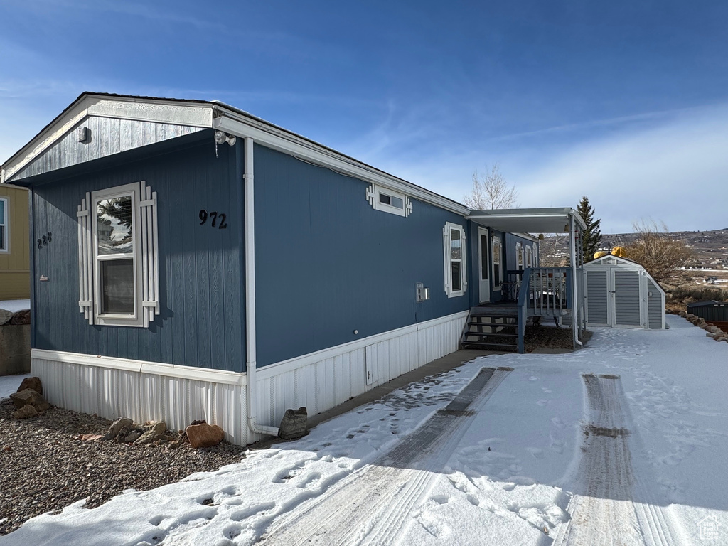 View of snow covered exterior featuring a storage shed