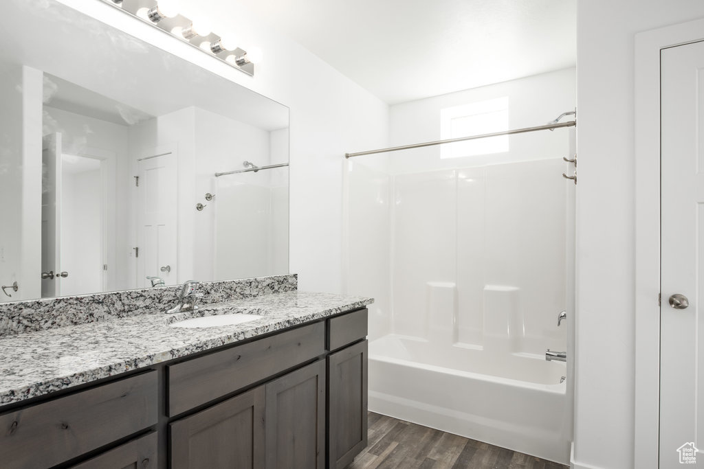 Bathroom with vanity,  shower combination, and hardwood / wood-style flooring