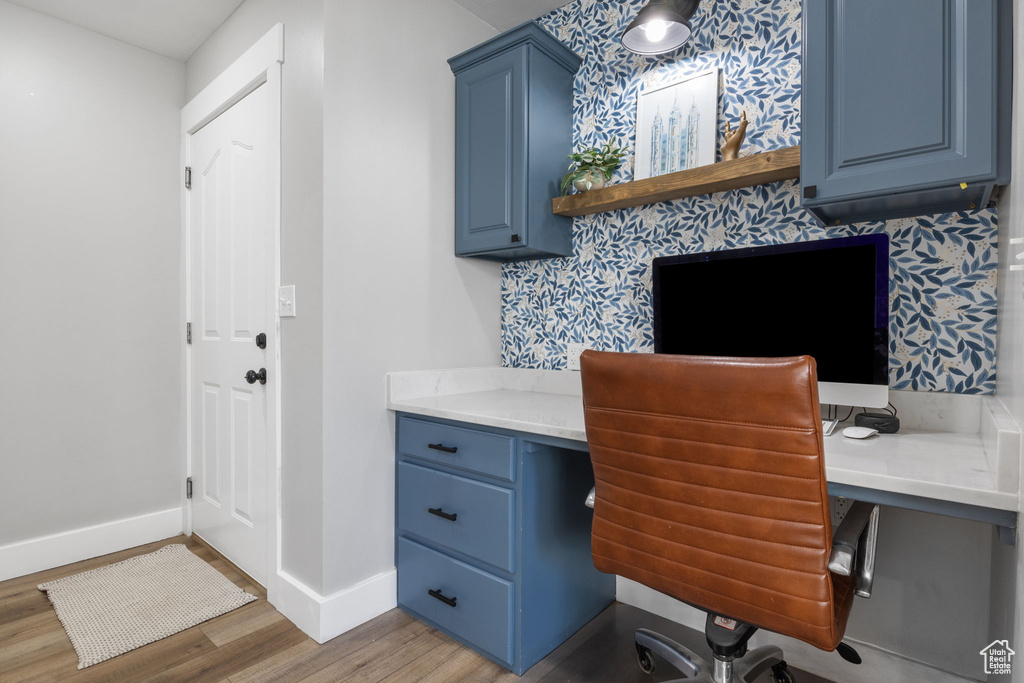 Office featuring built in desk and hardwood / wood-style flooring