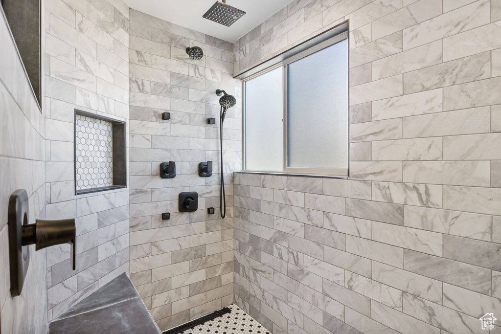 Bathroom featuring tiled shower and tile walls