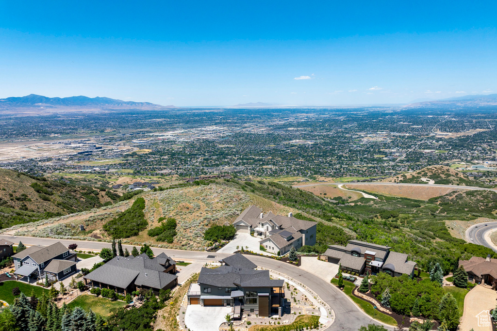 Aerial view of property and surrounding area with nearby suburban area and a mountainous background