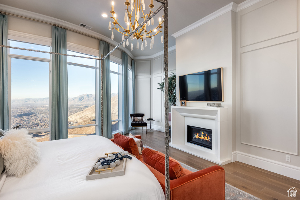 Bedroom featuring a chandelier, hardwood / wood-style flooring, and ornamental molding
